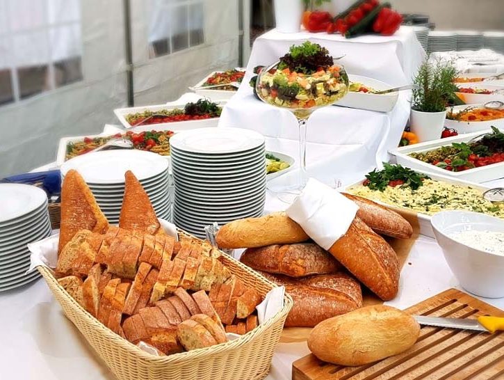 Buffet mit verschiedenen Brotsorten und weißem Geschirr